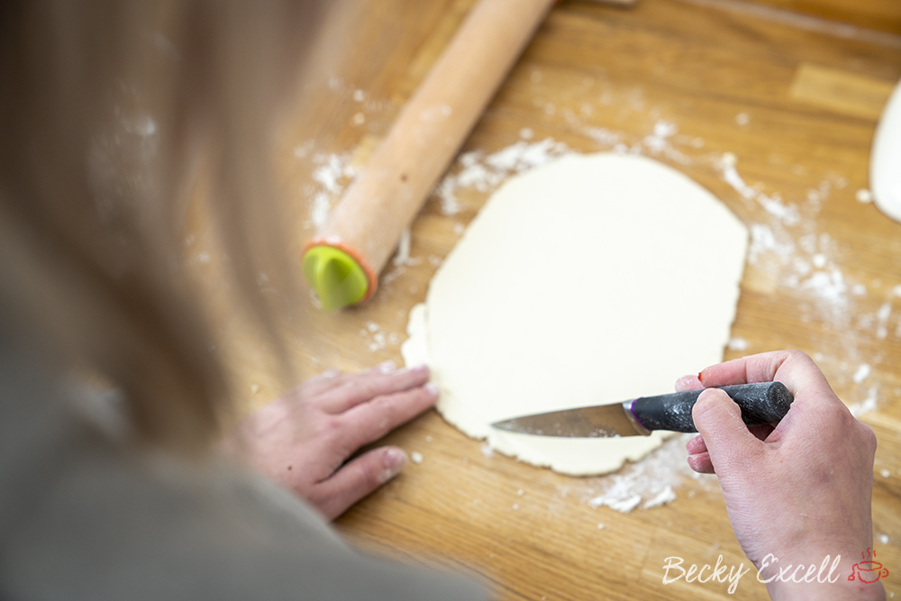 Use a sharp knife to refine the shape of your calzone dough a little better