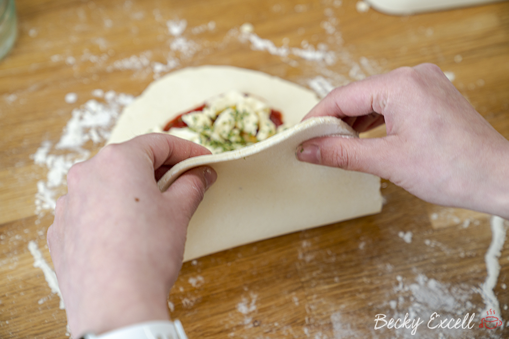 Fold your dough over to form the shape of our gluten free calzone, but leave 1cm of overhang