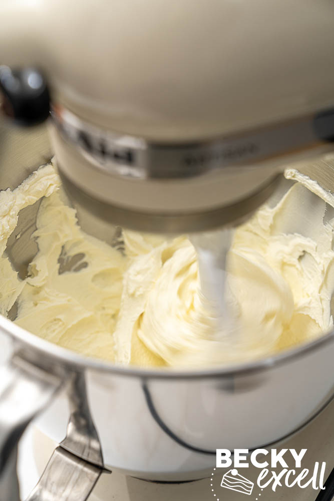 A KitchenAid stand mixer with paddle attachment mixing the full fat cream cheese