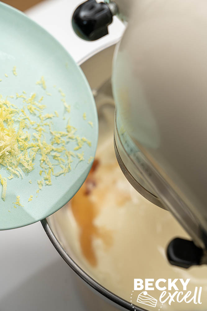 Adding the lemon zest and vanilla extract to the cheesecake filling mixture while the stand mixer is on low