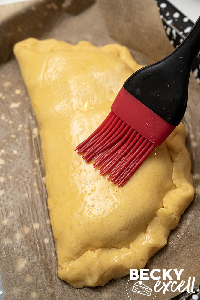 Brush with beaten egg mixed with a little water. I sieved mine for a smooth, consistent glaze.