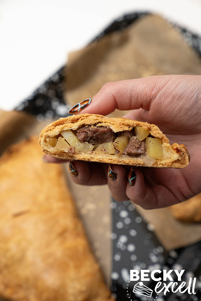 Handheld cross-section of my gluten-free Cornish pasty revealing the inside filling