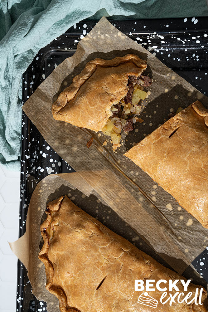 A close up of the Cornish pasty sliced in half with beef, swede and onion filling spilling out
