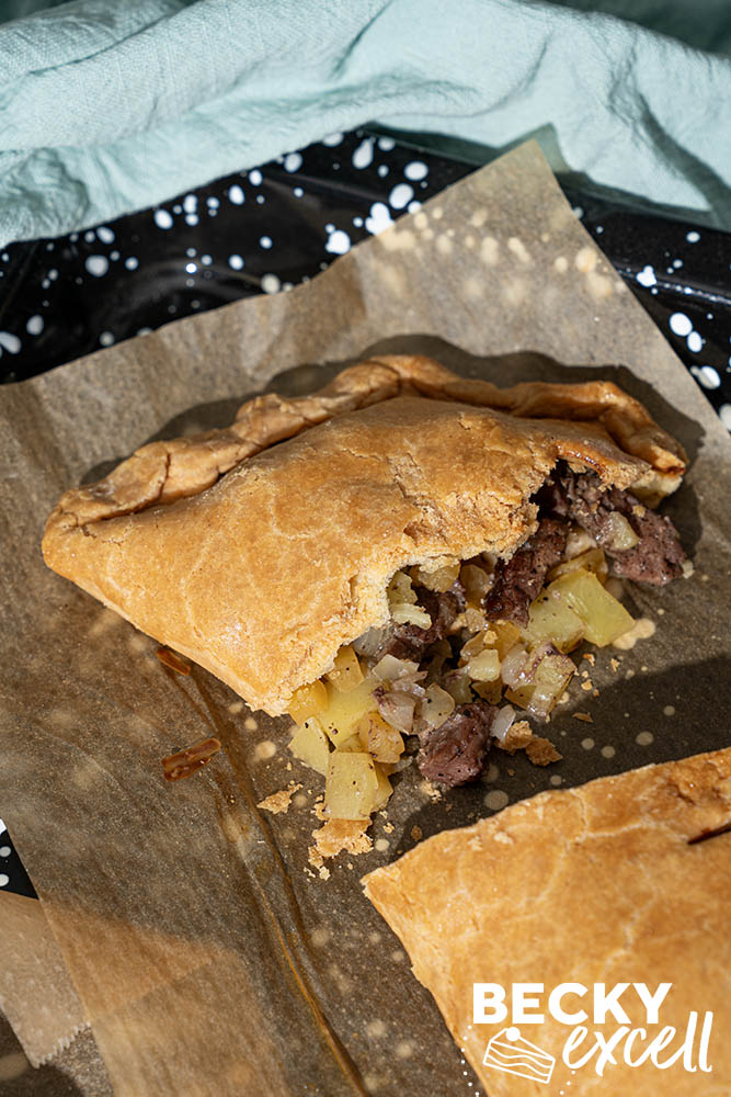 Golden crimped gluten-free pastry around a sliced beef, potato and swede pasty