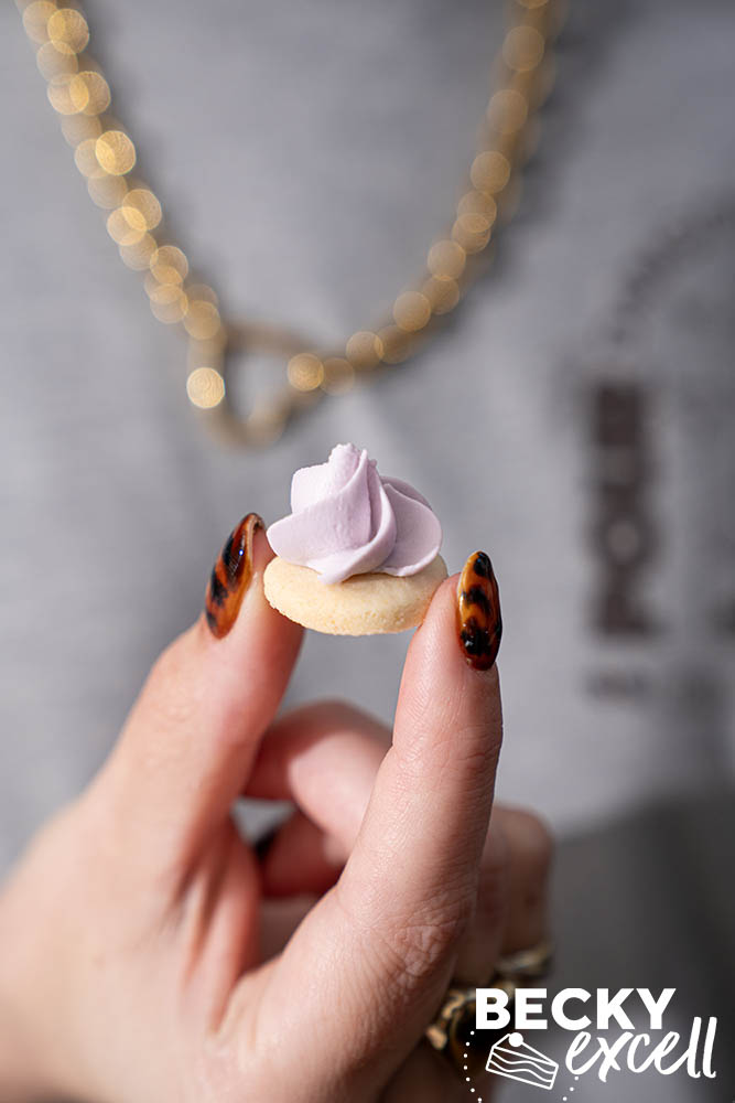 recipe author holding a single gluten-free iced gem for scale and size reference